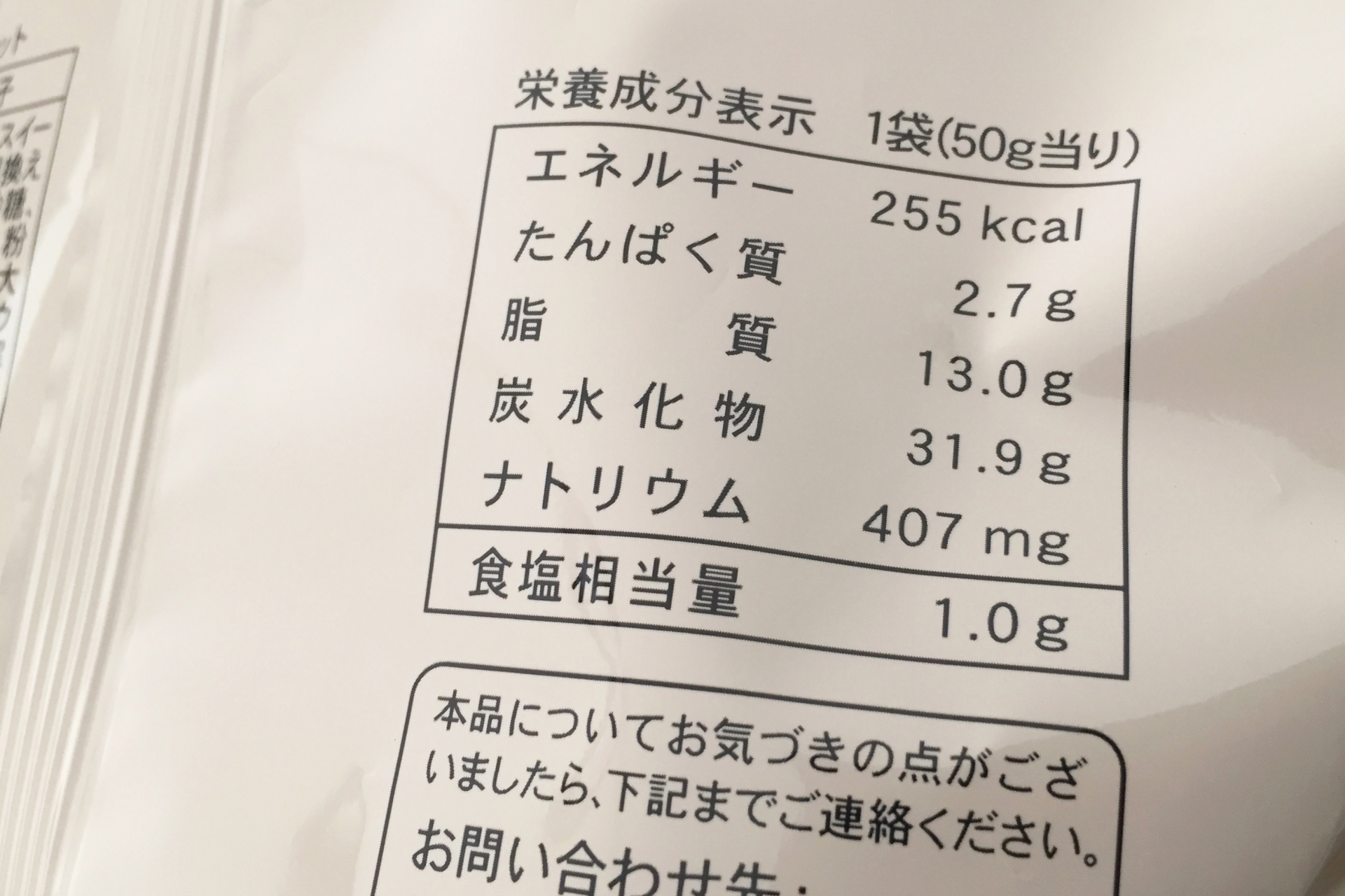 実際の市販パンの食品表示ラベル全体写真。栄養成分表示欄にエネルギー・たんぱく質・脂質・炭水化物・食塩相当量が記載されており、原材料名・アレルゲン表示も確認できる